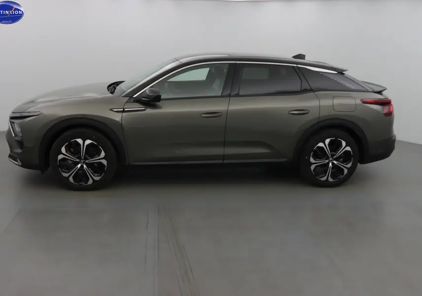 Profil côté gauche d'une Citroën C5 X hybride rechargeable gris smart avec jantes noires et toit noir contrasté.
