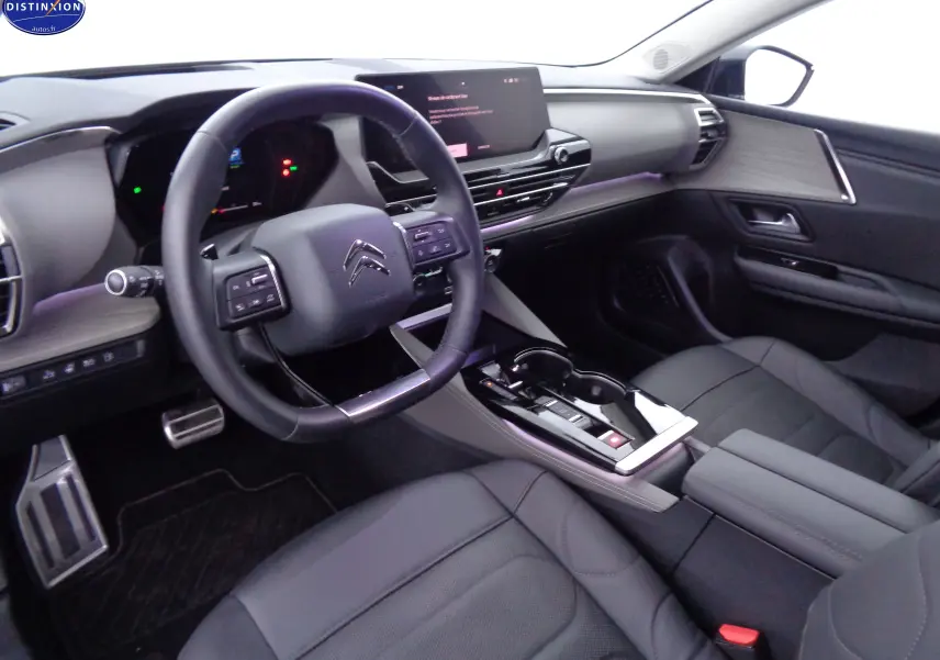 Intérieur avant droit du Citroën C5 X hybride rechargeable 2022, avec tableau de bord moderne et sellerie cuir noir.
