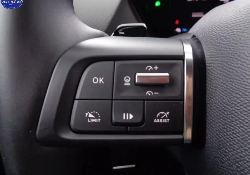 Gros plan sur les commandes au volant du Citroën C5 X hybride gris smart, boutons de régulateur de vitesse et assistances visibles.