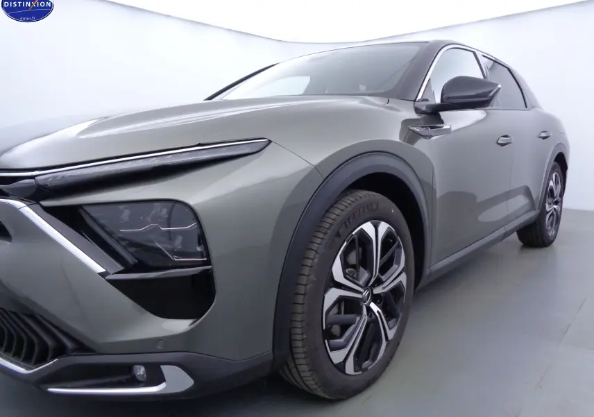 Vue 3/4 avant droit d'une Citroën C5 X hybride rechargeable gris smart avec jantes bi-ton et phares LED distinctifs.