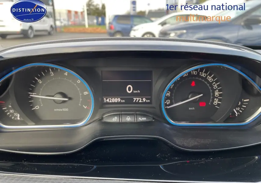Tableau de bord de Peugeot 2008 blanc 2016, affichant 142889 km, vue frontale du combiné d'instruments.