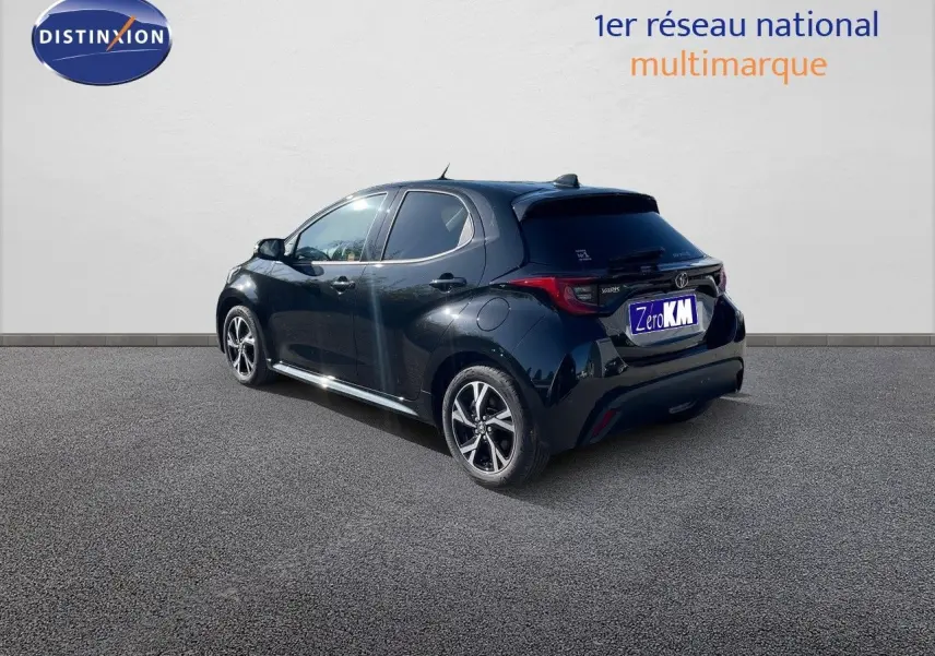 Vue 3/4 arrière droite d'une Toyota Yaris Hybrid 116ch noire métal avec jantes bi-ton et vitres teintées.