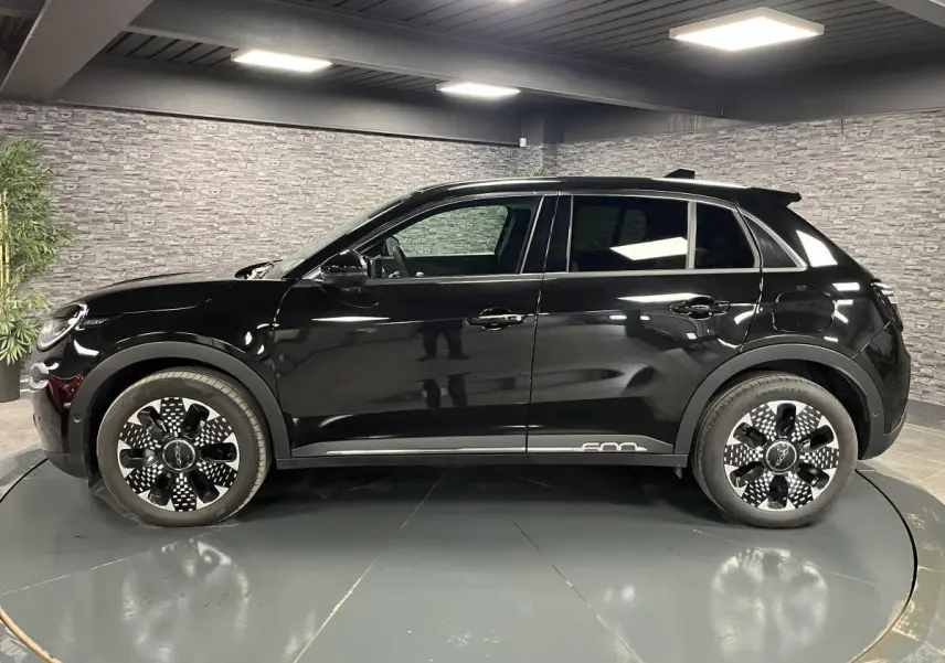Profil côté gauche d'une FIAT 600 noire 2024 avec jantes alliage diamantées et logo 600 chromé sur bas de caisse