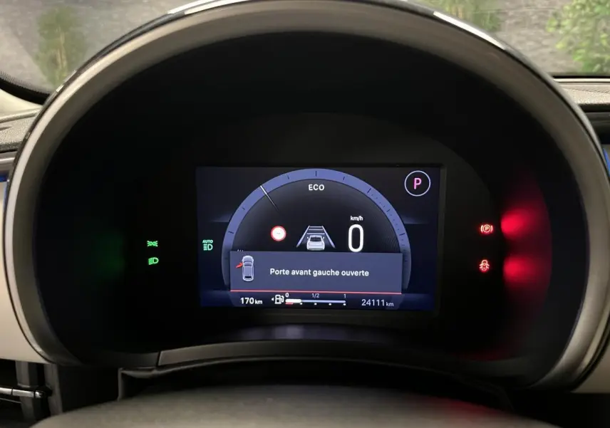 Vue rapprochée du combiné numérique 7 pouces du tableau de bord ivoire du Fiat 600 noir, affichant porte avant gauche ouverte.