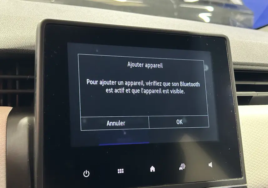 Écran tactile central de la Renault Clio V TCe 90 TECHNO 2023 affichant un message d'ajout Bluetooth.