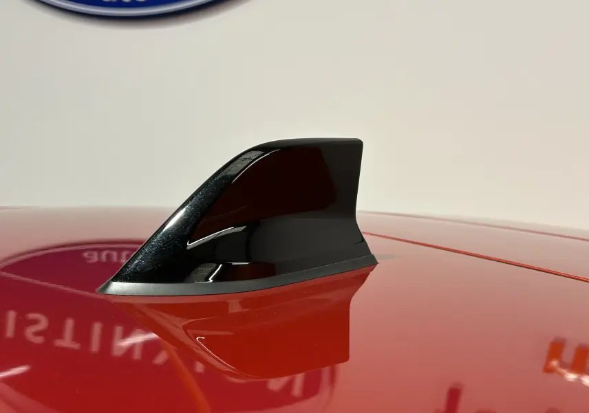 Antenne requin noire en gros plan sur le toit rouge brillant d'une Renault Clio V TCe 90 TECHNO 2023.