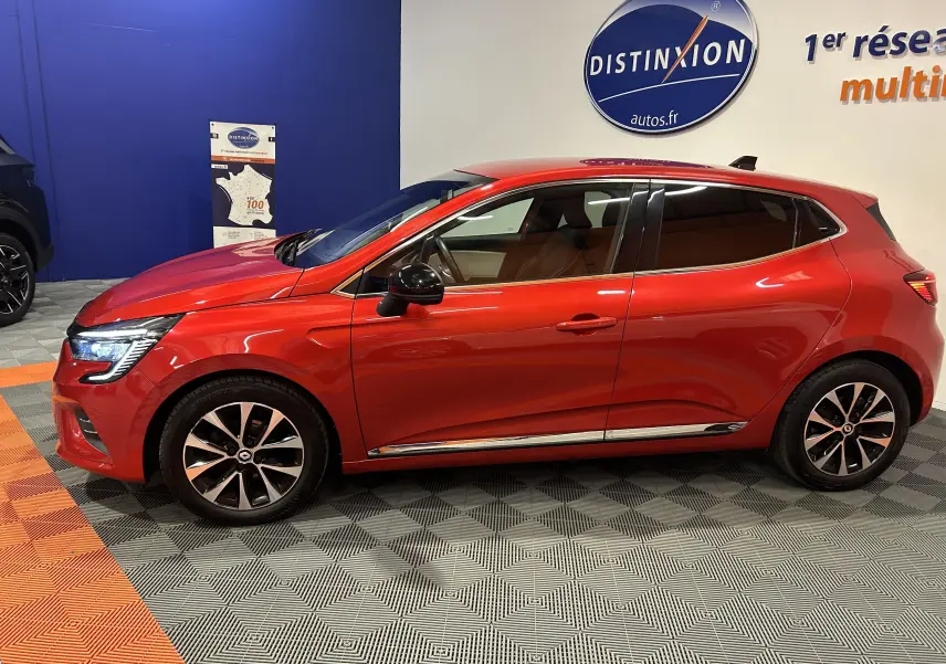 Profil droit d'une Renault Clio V rouge 2023 en finition TCe 90 TECHNO, avec jantes alliage et vitres teintées.