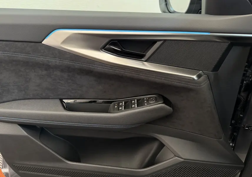 Détail de la porte côté conducteur du Renault Espace gris foncé 2025 avec garniture noire et surpiqûres bleues