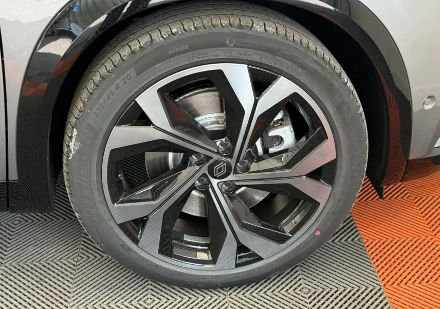 Gros plan sur la roue avant droite du Renault Espace gris foncé esprit Alpine avec jante alliage moderne à motifs noirs et argentés.