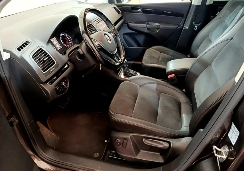 Intérieur avant droit du Volkswagen Sharan marron 2017, montrant sièges cuir et tableau de bord avec volant multifonctions.