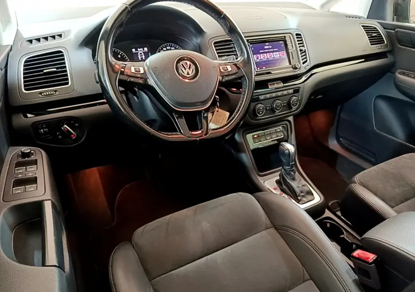 Intérieur du Volkswagen Sharan 2017, vue du poste de conduite avec volant cuir et écran tactile central.