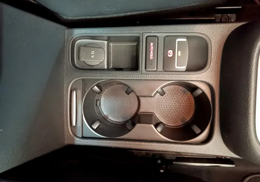 Vue en plongée sur la console centrale noire du Volkswagen Sharan 2017 montrant porte-gobelets et commandes électriques.