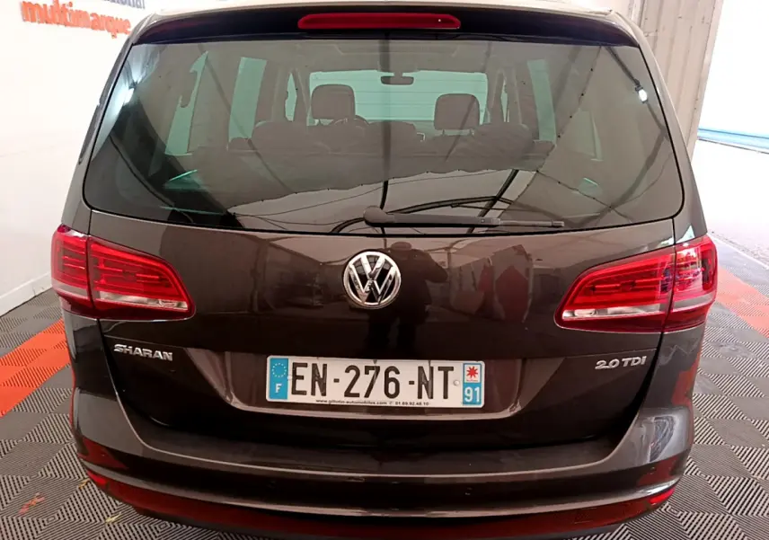 Vue arrière d'un Volkswagen Sharan marron 2.0 TDI avec feux rouges et plaque d'immatriculation française visible