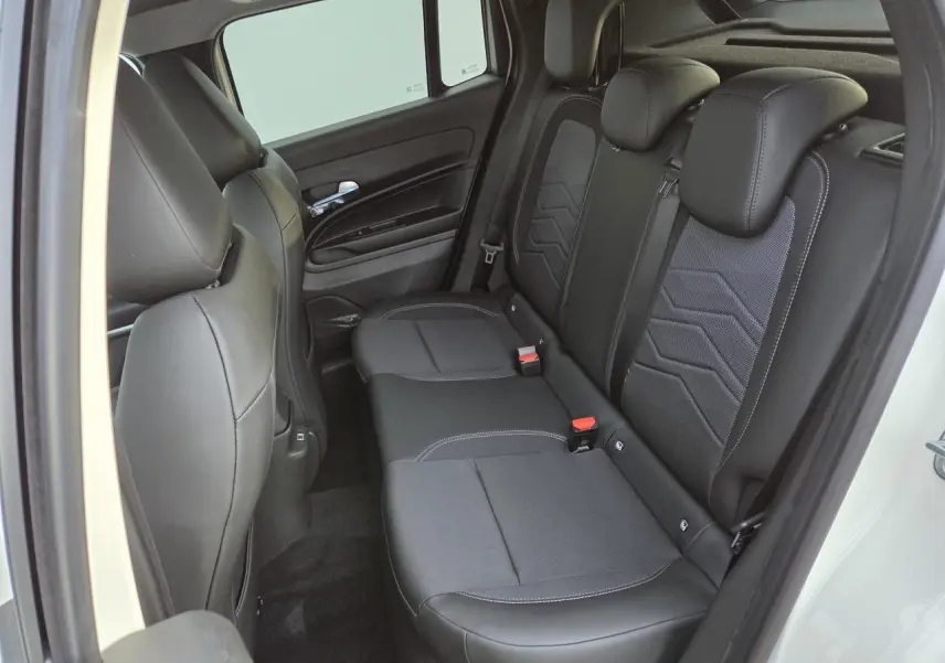 Vue côté droit sur la banquette arrière noire mixte tissu et TEP du Jeep Avenger 2025 couleur Snow avec détails gris.