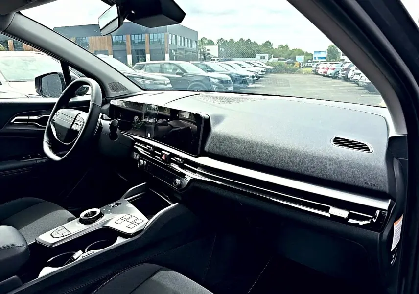 Vue intérieure côté conducteur du Kia Sportage 1.6 hybride 239 gris eclipse, avec tableau de bord moderne et écran tactile large.