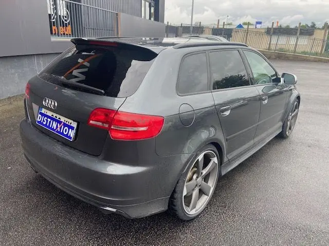 Audi RS3 Sportback gris Daytona vue 3/4 arrière droit, avec jantes alliage et vitres teintées.