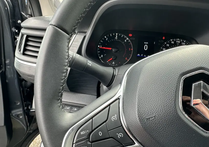 Gros plan sur le volant en cuir noir et le tableau de bord digital du Renault Trafic Combi gris Comète 2023.