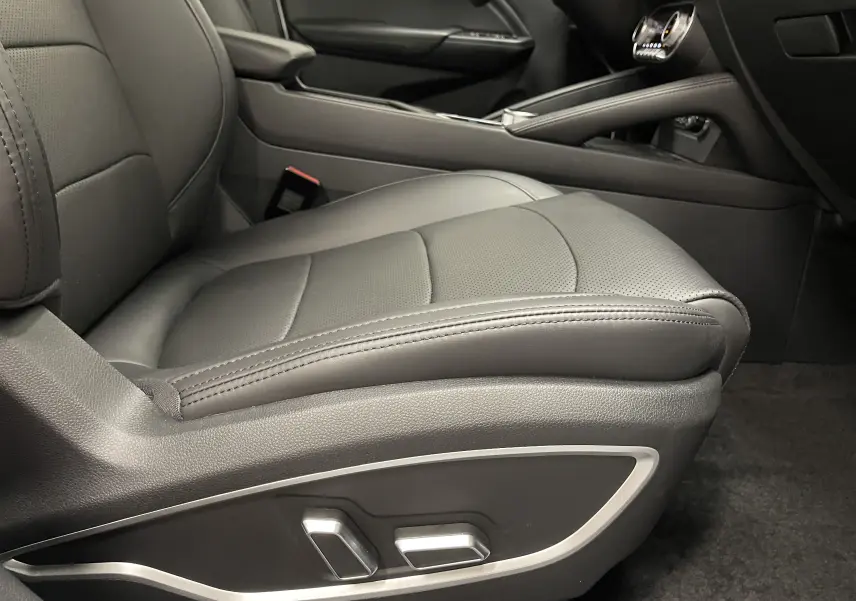 Gros plan sur le siège conducteur noir électrique du SERES 3 Luxury, mettant en valeur les commandes de réglage sur le côté.