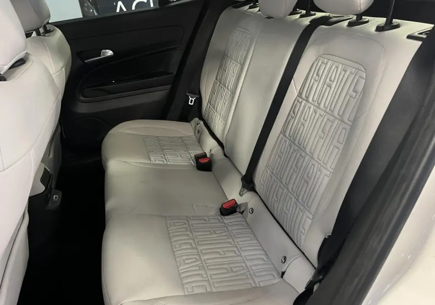 Vue intérieure arrière de la banquette ivoire soft touch avec monogrammes FIAT embossés sur la Fiat 600 blanche 2024.