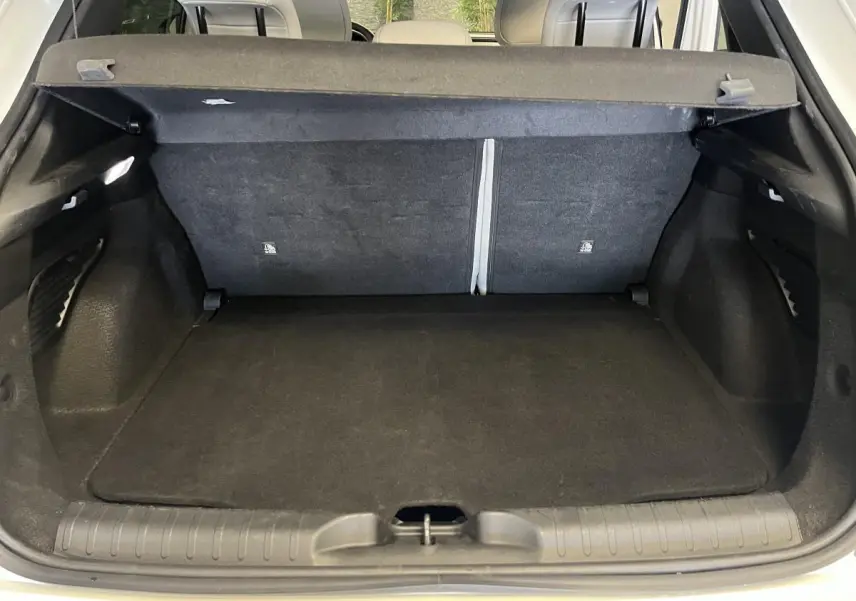 Coffre ouvert noir de la FIAT 600 1.2 Hybrid 2024 vue arrière avec banquette rabattable et cache-bagages.