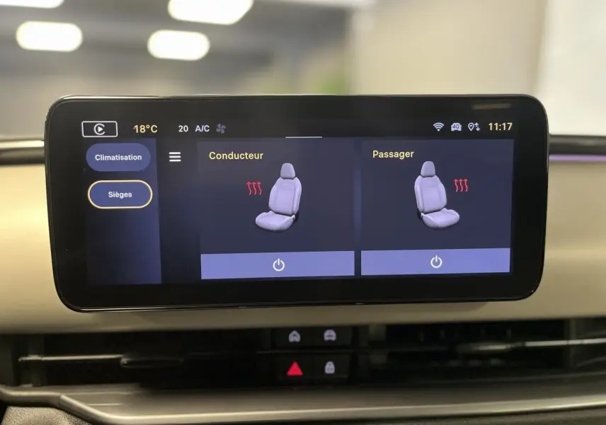 Écran tactile du système Uconnect affichant le réglage des sièges chauffants dans une FIAT 600 blanche, vue intérieure frontale.