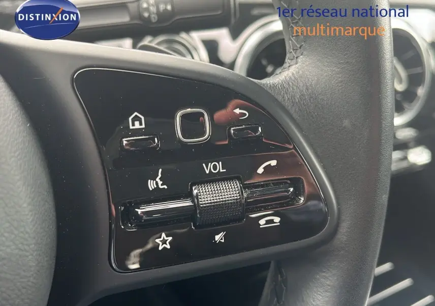 Gros plan sur les commandes de volume et téléphone au volant cuir noir d'une Mercedes CLA Shooting Brake argent iridium.