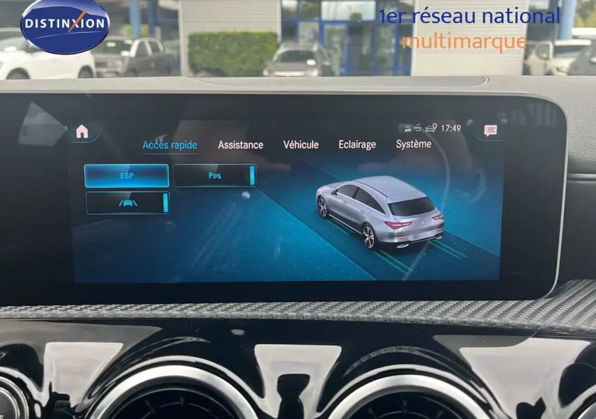 Écran multimédia montrant une Mercedes Classe CLA Shooting Brake argent iridium en vue 3/4 arrière sur interface d'assistance.