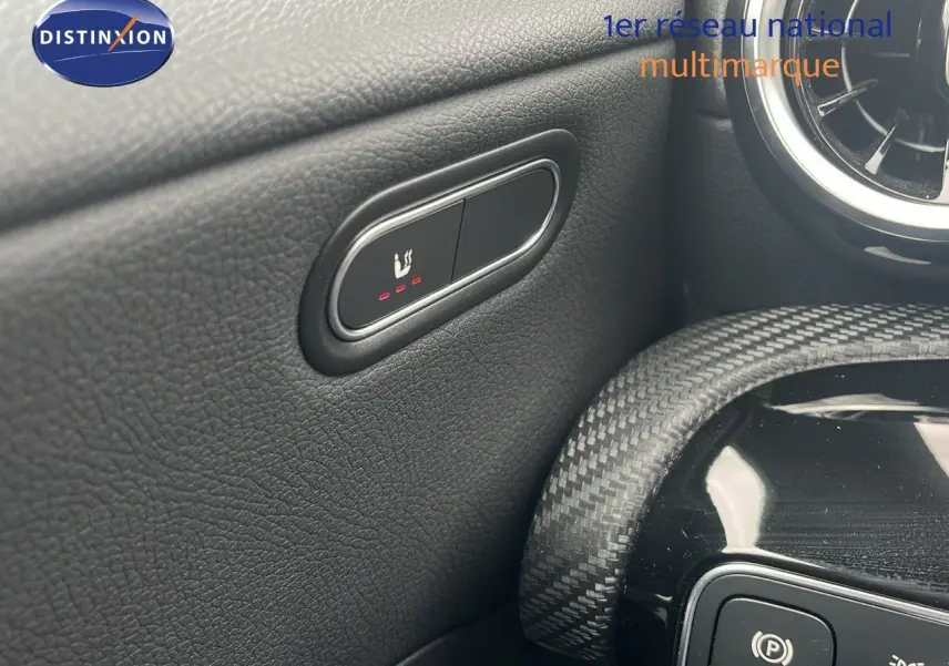 Gros plan sur le bouton de siège chauffant côté conducteur dans l'habitacle noir d'une Mercedes CLA Shooting Brake 2020.