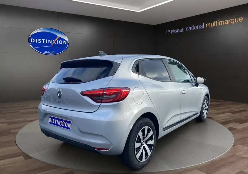 Renault Clio V gris Highland vue 3/4 arrière droit, vitres arrière surteintées et feux LED distinctifs.