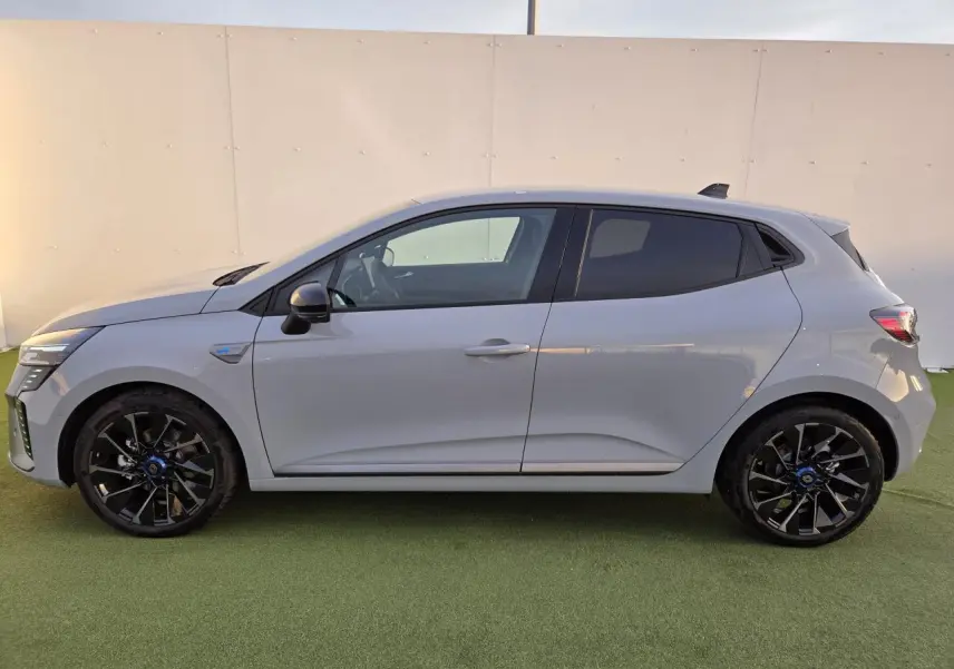 Profil droit d'une Renault Clio V hybride gris Rafale avec jantes alliage noires et vitres surteintées.