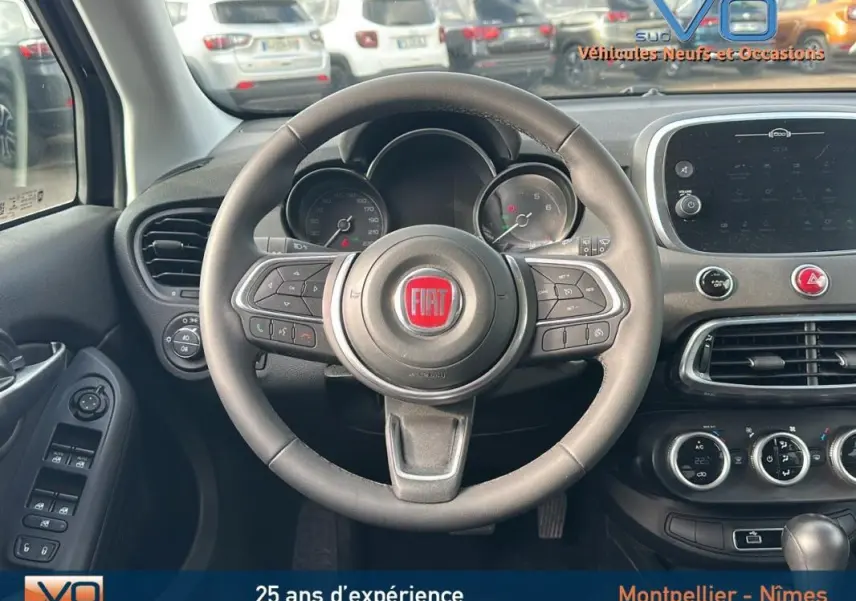 Vue centrée sur le volant et tableau de bord du Fiat 500X noir MY23 avec commandes au volant et écran tactile.