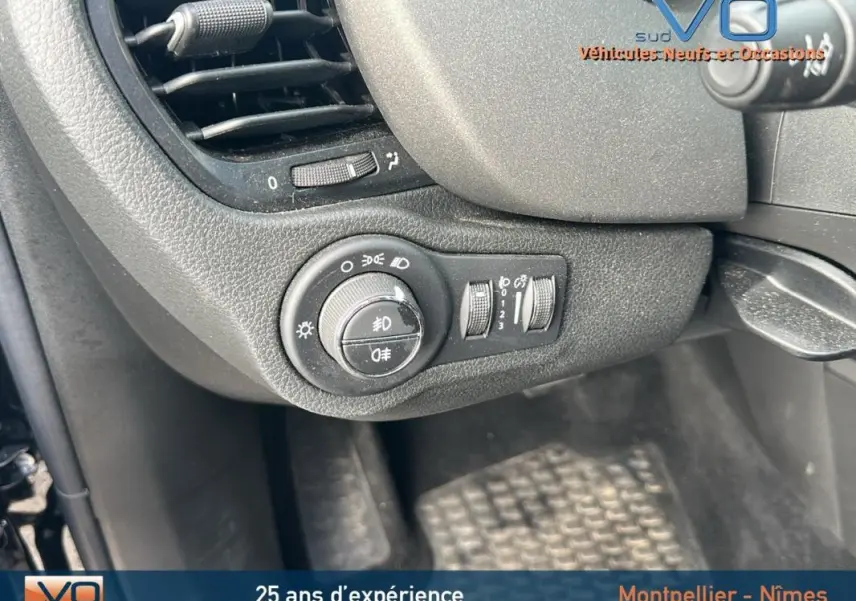 Gros plan sur le tableau de bord noir du Fiat 500X MY23, avec commandes des phares et ventilation visibles.