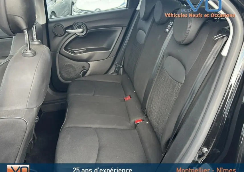 Vue intérieure côté droit des sièges arrière noirs du Fiat 500X MY23 avec ceintures et appuie-têtes visibles.