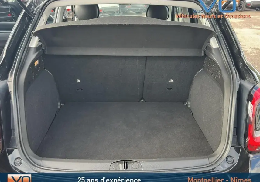 Coffre ouvert de la FIAT 500X noir MY23, vue arrière montrant l'espace de chargement vide et la plage arrière.