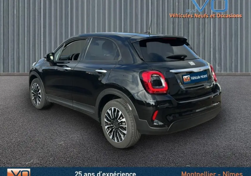 Vue 3/4 arrière droite d'une FIAT 500X noire 2023 avec jantes classiques 16 pouces et feux arrière distinctifs.