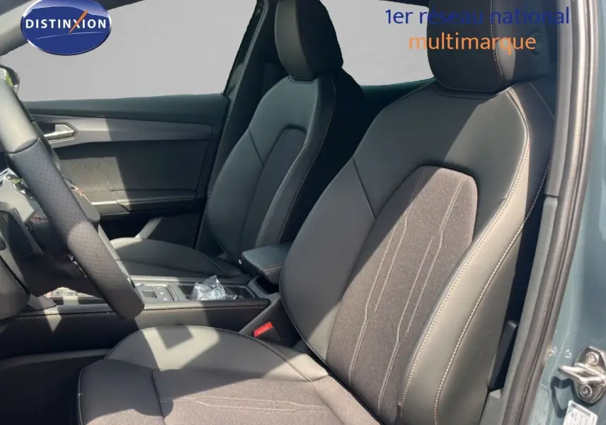 Vue intérieure côté conducteur du CUPRA Formentor 1.5 eTSI 2026 avec sièges en tissu et cuir noir, détails de la console centrale visibles.