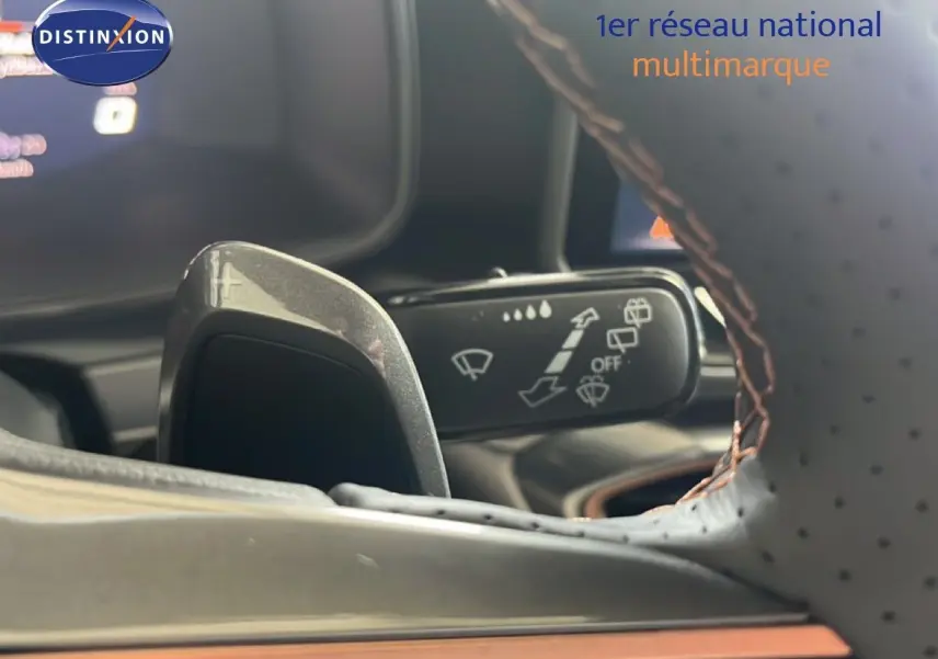 Gros plan sur la palette de changement de vitesse et la commande d’essuie-glace derrière le volant perforé du CUPRA Formentor bleu Fjord.