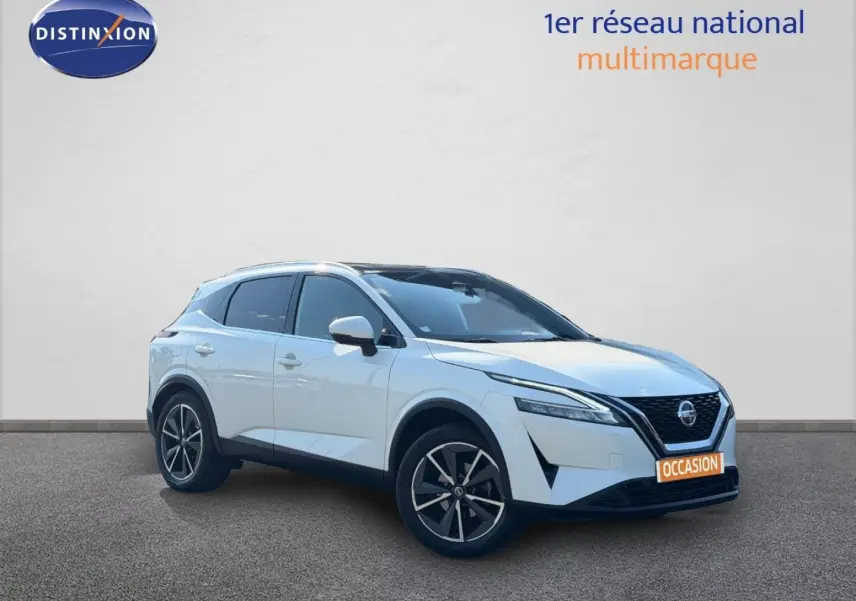 Nissan Qashqai blanc en 3/4 avant droit, avec jantes alliage noires et calandre distinctive V-Motion.