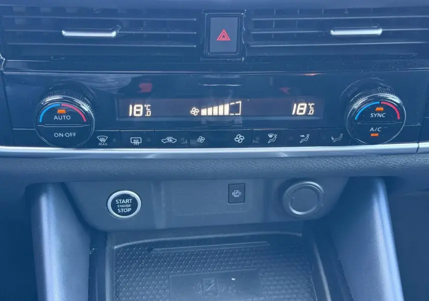 Détail de la console centrale du Nissan Qashqai rouge 2022, montrant la climatisation bi-zone et bouton start/stop.