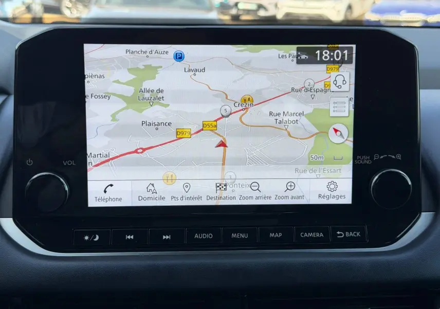 Écran tactile central du Nissan Qashqai 2022 affichant la navigation GPS avec commandes audio et menu en dessous.
