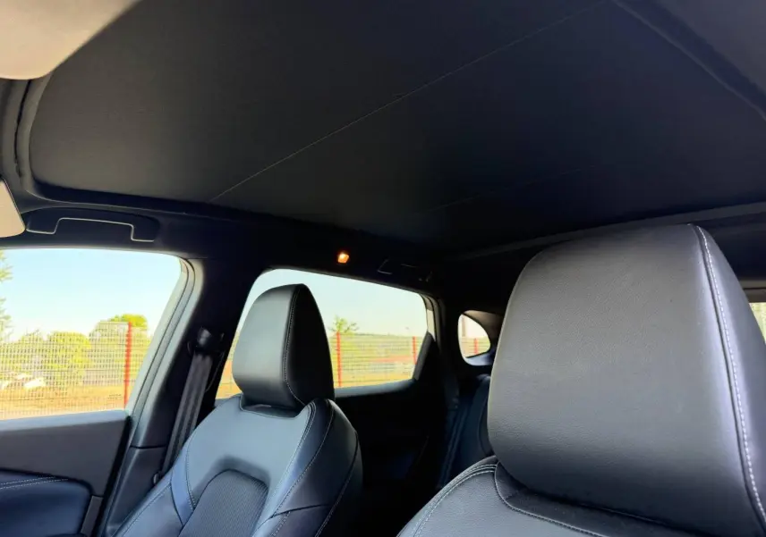 Vue intérieure du Nissan Qashqai 1.3 Mild Hybrid 2022, sièges avant en cuir noir avec surpiqûres blanches.