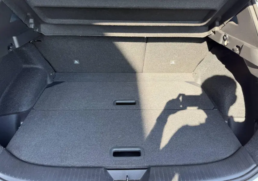 Coffre spacieux gris foncé du Nissan Qashqai 1.3 Mild Hybrid 2022, vue intérieure avec plancher plat et poignées intégrées.