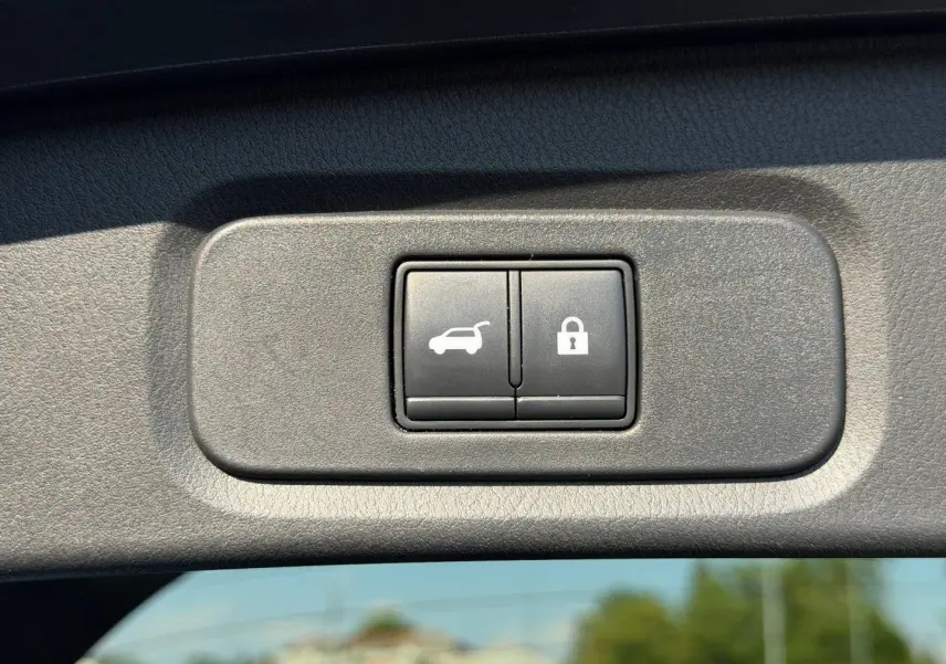 Gros plan sur les boutons d'ouverture et de verrouillage du coffre du Nissan Qashqai rouge 2022.