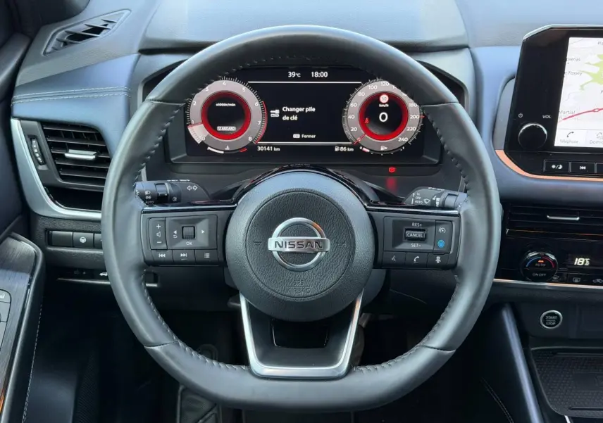 Vue centrée sur le volant cuir noir du Nissan Qashqai 2022 avec tableau de bord numérique et écran tactile latéral.