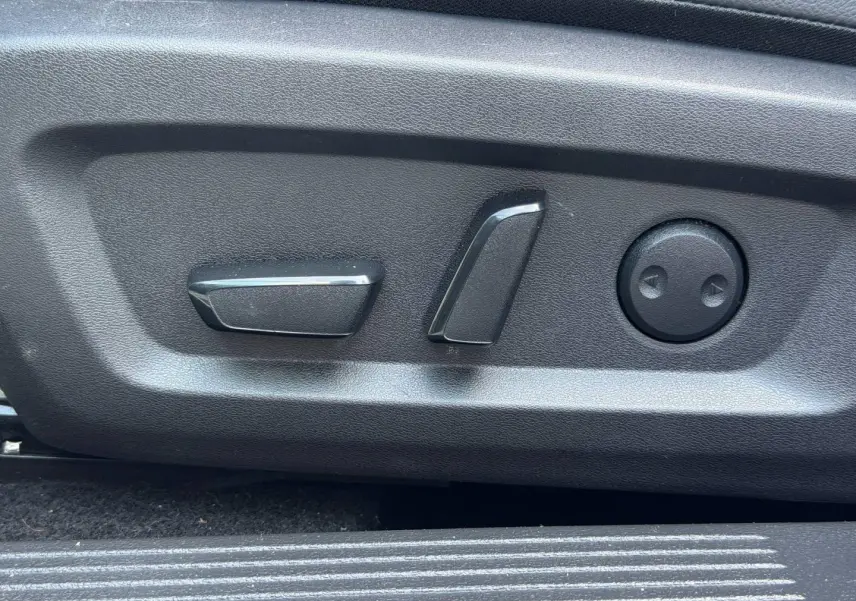 Gros plan sur les commandes électriques de réglage du siège conducteur du Nissan Qashqai Tekna 2022, finition noire.