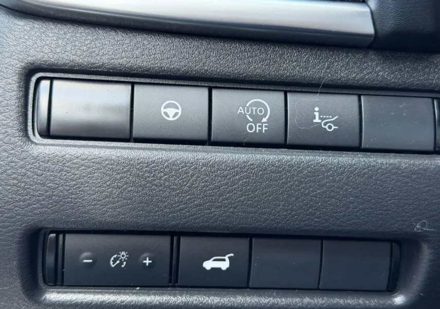 Gros plan sur les boutons de commande noirs du tableau de bord intérieur du Nissan Qashqai rouge 2022.