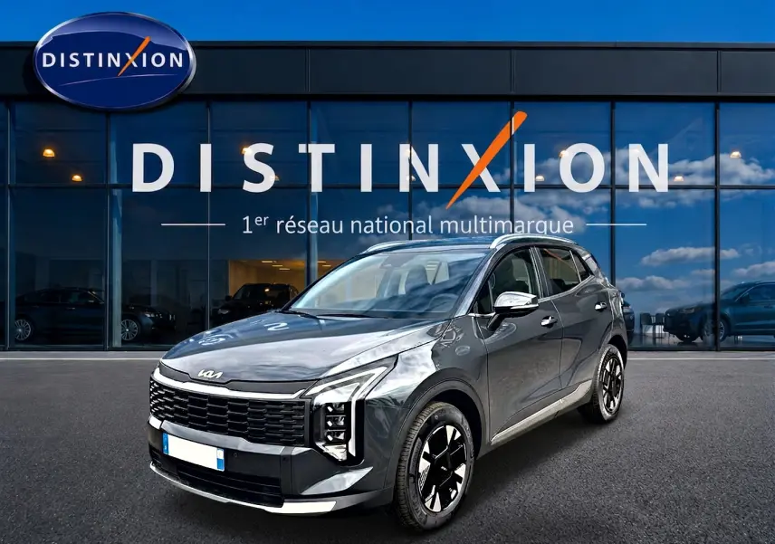 KIA Sportage 1.6 hybride gris eclipse en 3/4 avant droit, avec calandre noire et jantes alu noires et argentées.