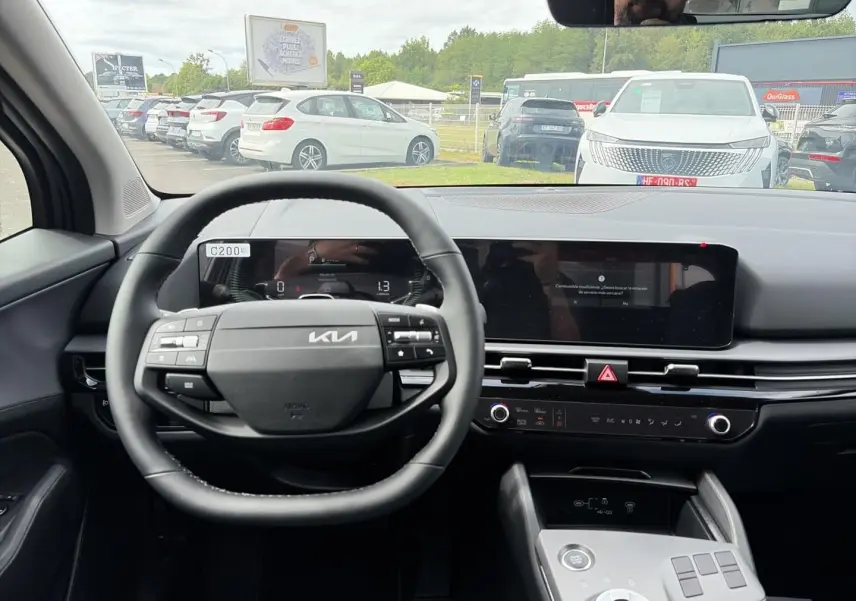Vue intérieure centrée sur le volant cuir multifonction et l'écran tactile du Kia Sportage gris eclipse 2026.