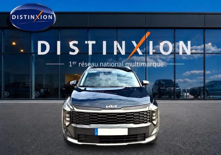 Vue frontale d'un KIA Sportage 1.6 hybride 239 gris eclipse avec calandre noire et phares LED distinctifs.