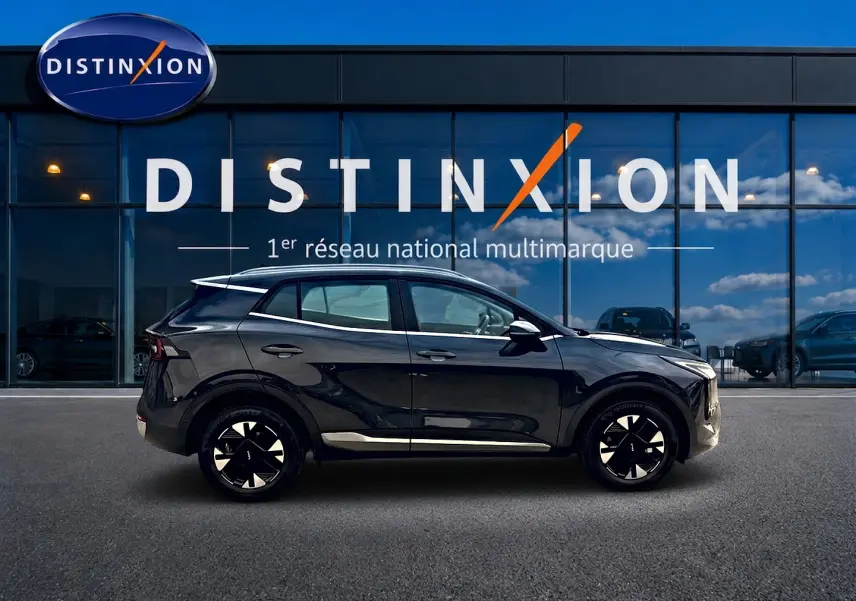 Profil côté gauche du KIA Sportage 1.6 hybride 239 gris eclipse, avec jantes alu et barres de toit visibles.